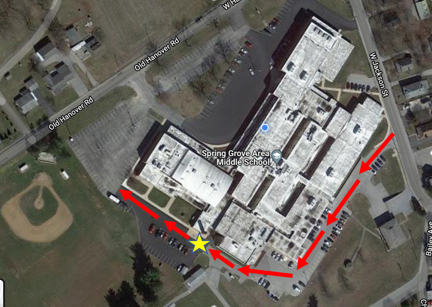Google Maps image of Middle School. Red arrows to indicate enter at West Jackson and wrap around behind building.